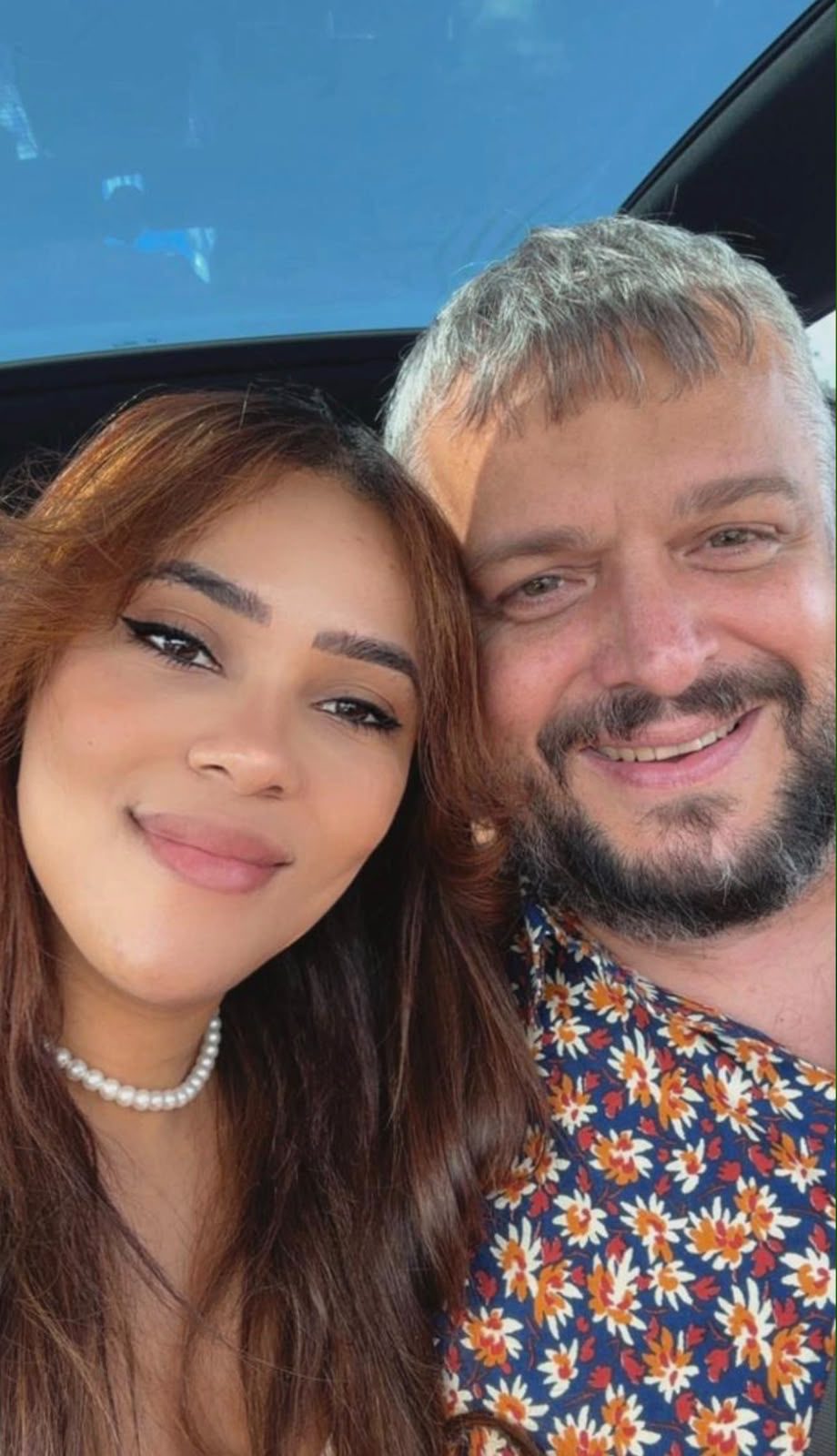 James and Cyntia smiling together in the car